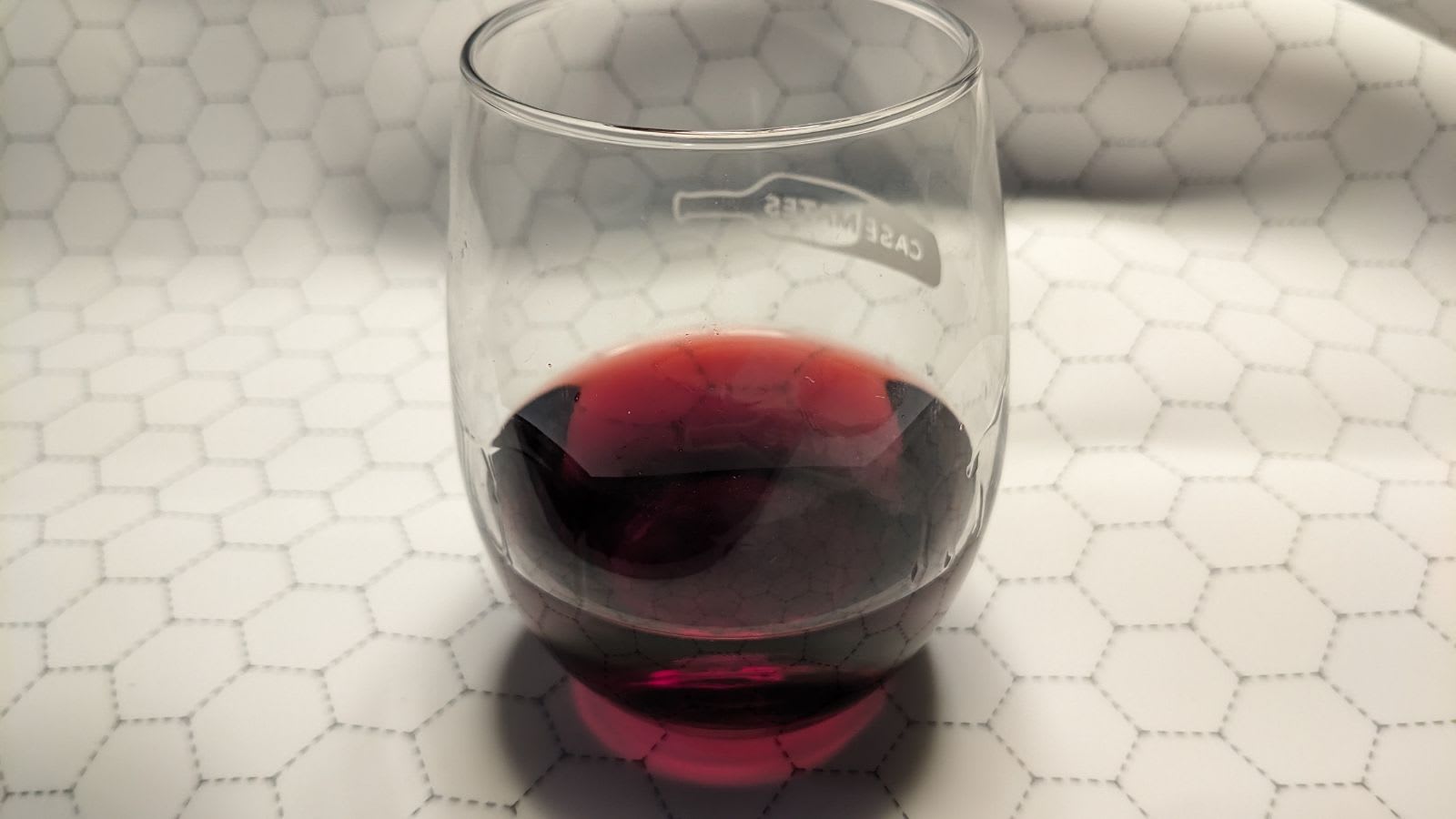 Light highlighting the ruby clarity of the wine in a Case Mates glass