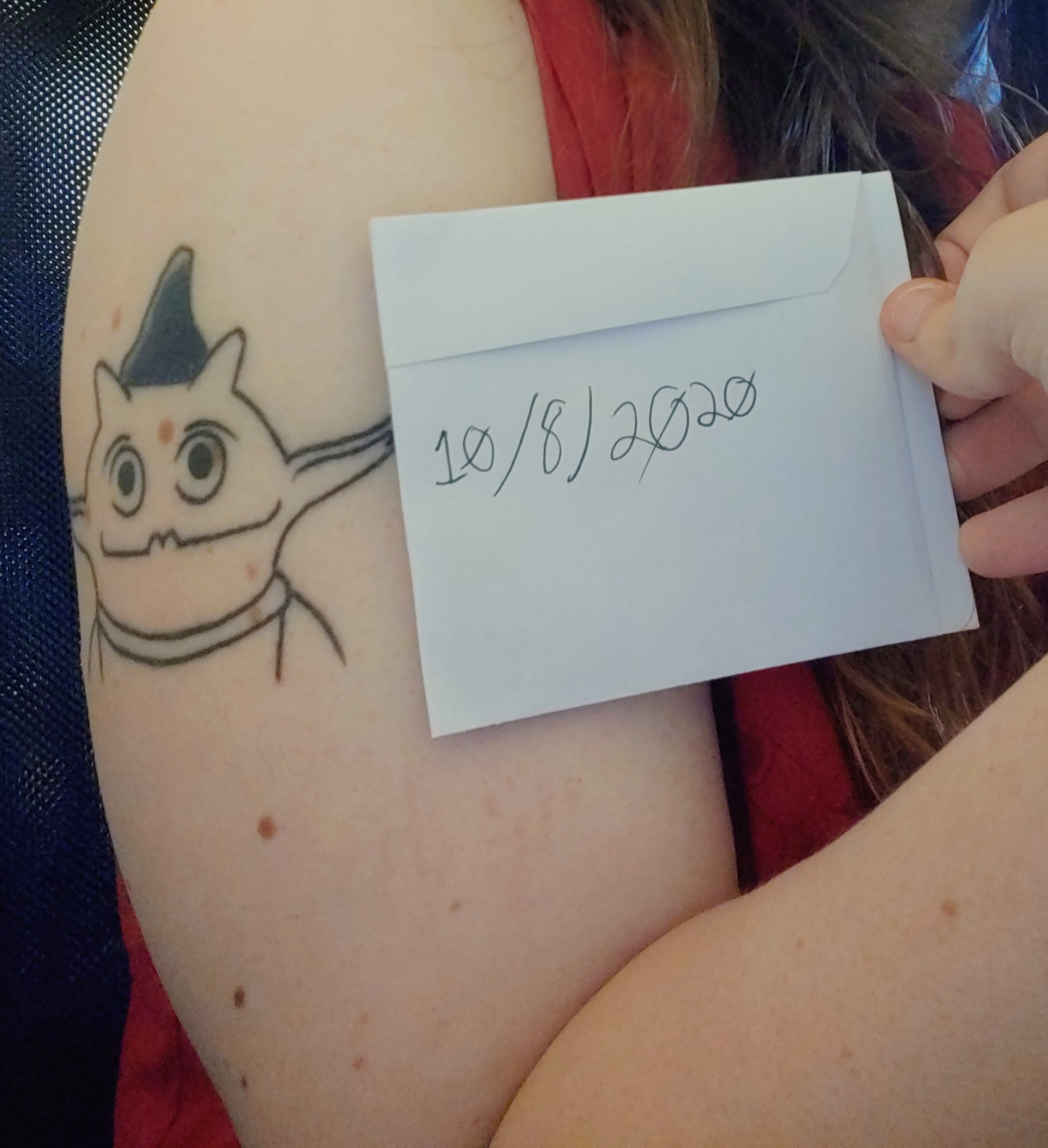 picture of tattoo with 10/8/2020 written on paper next to it