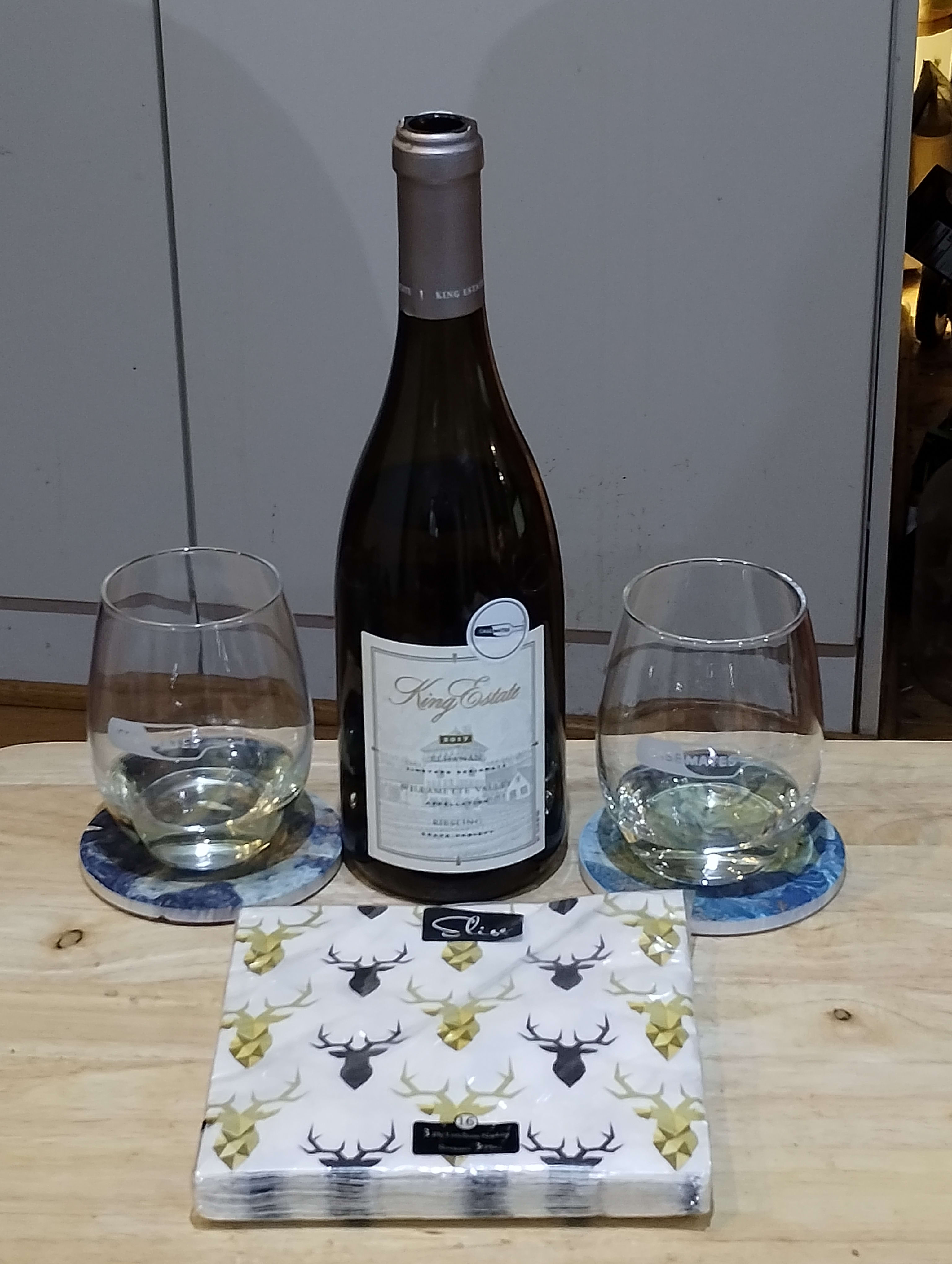 Bottle of wine with two wineglasses with a bit of pale white wine in them