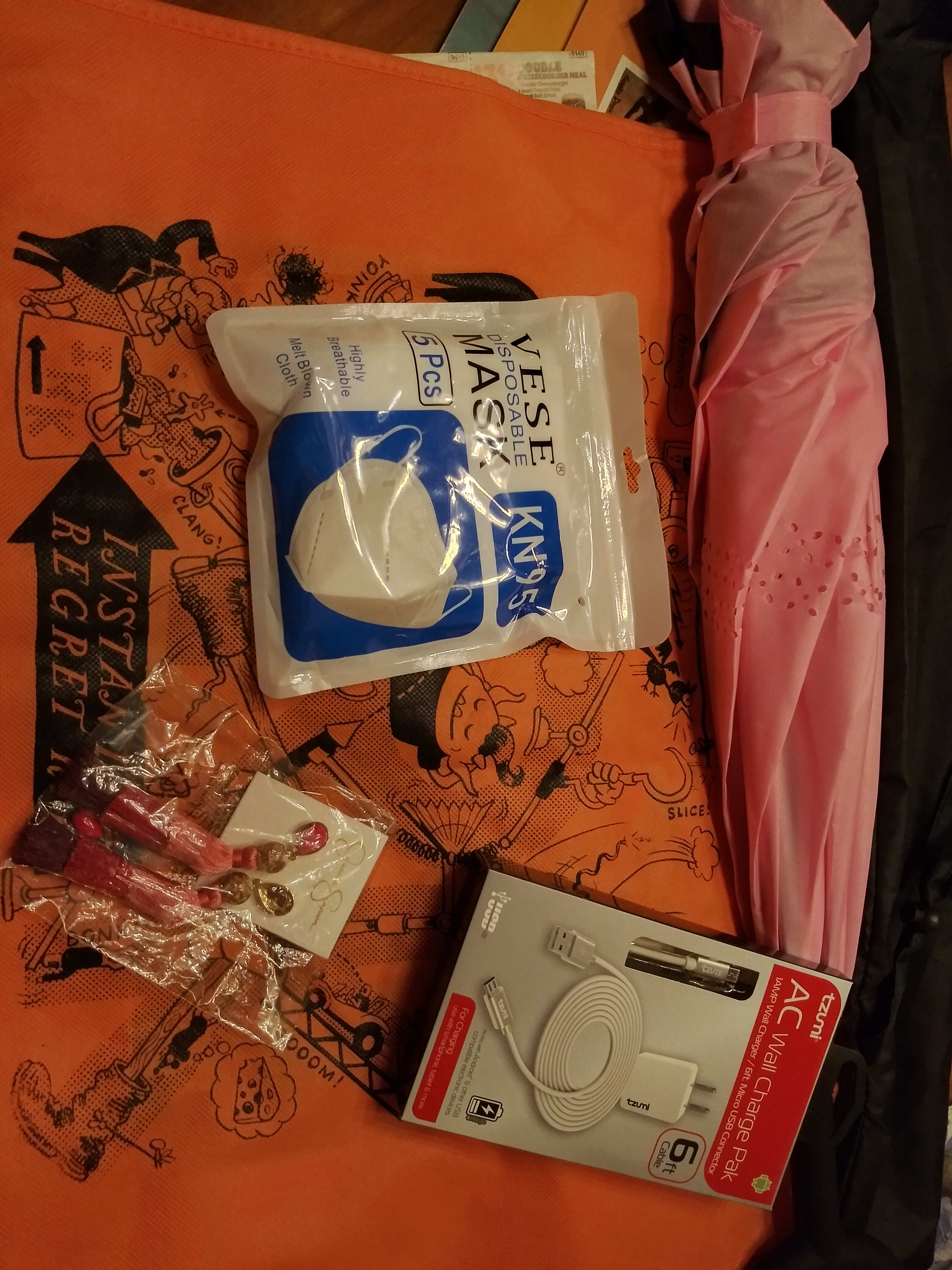 orange irk bag, reverse umbrella, USB cord, Jessica Simpson earrings, kn95 masks