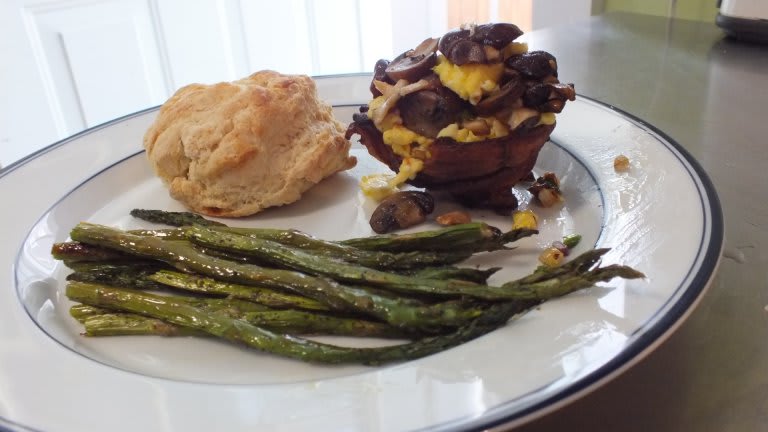 Bacon cup with eggs served with a biscuit and roasted asparagus