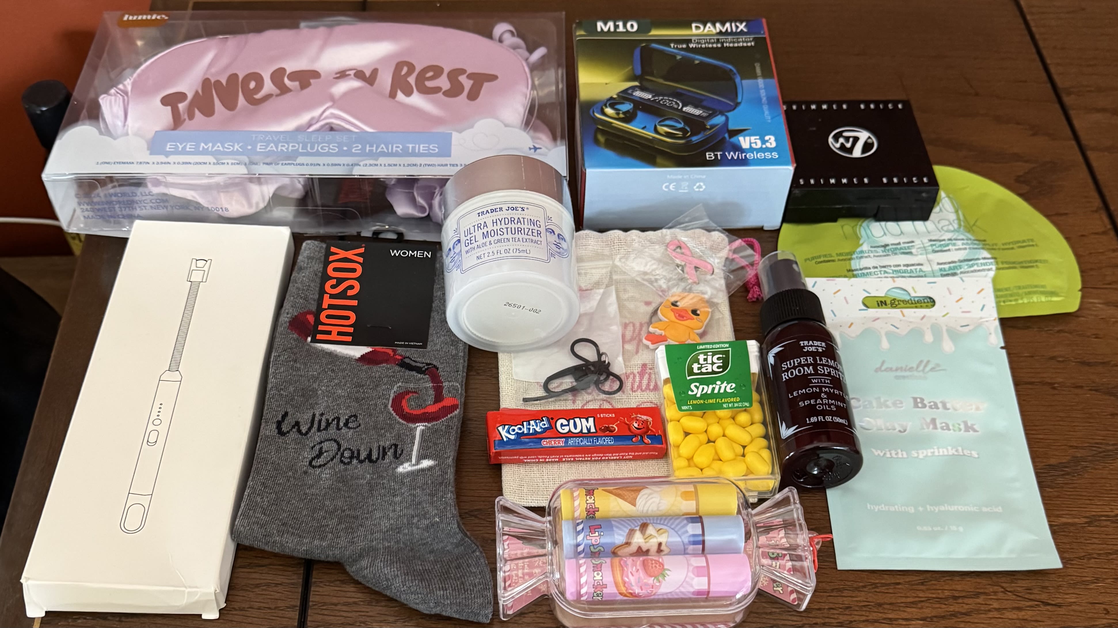 so I got my box on Monday but mono has been kicking my butt. What a great assortment of goodies I got from @cutterbug. As an avid Trader Joe’s shopper, some of these food items I’ve never seen before so very cool. My two favorite things are my funny wine socks and the electric lighter (from my wishlist). My grandma had one of these lighters and when my brothers and I would go there we would always dare each other to stick our fingers in it. After she died I wanted it for the memories but someone took it. I’m glad I have my own and I can now continue to zap them with it. Also In the box is sleeping mask, with scrunchies and ear plugs- i have a bunch I rotate through/loose in bed while my boyfriend likes to fall asleep with the tv on and I can’t stand light. I’m gonna try the ear plugs as he snores loud enough to vibrate the bed and I end up clapping in his ears, shaking him and hitting him just to disrupt his sleep so I can get peace and quite for 10 mins to fall asleep. Face masks, chapstick, gum, tic tacs, rubber duckie key chain, breast cancer pin, bow clip, ear plugs-can always another pair, TJ’s moisturizer which is actually a dupe for Clinique, TJ’s room spray and bronzer.