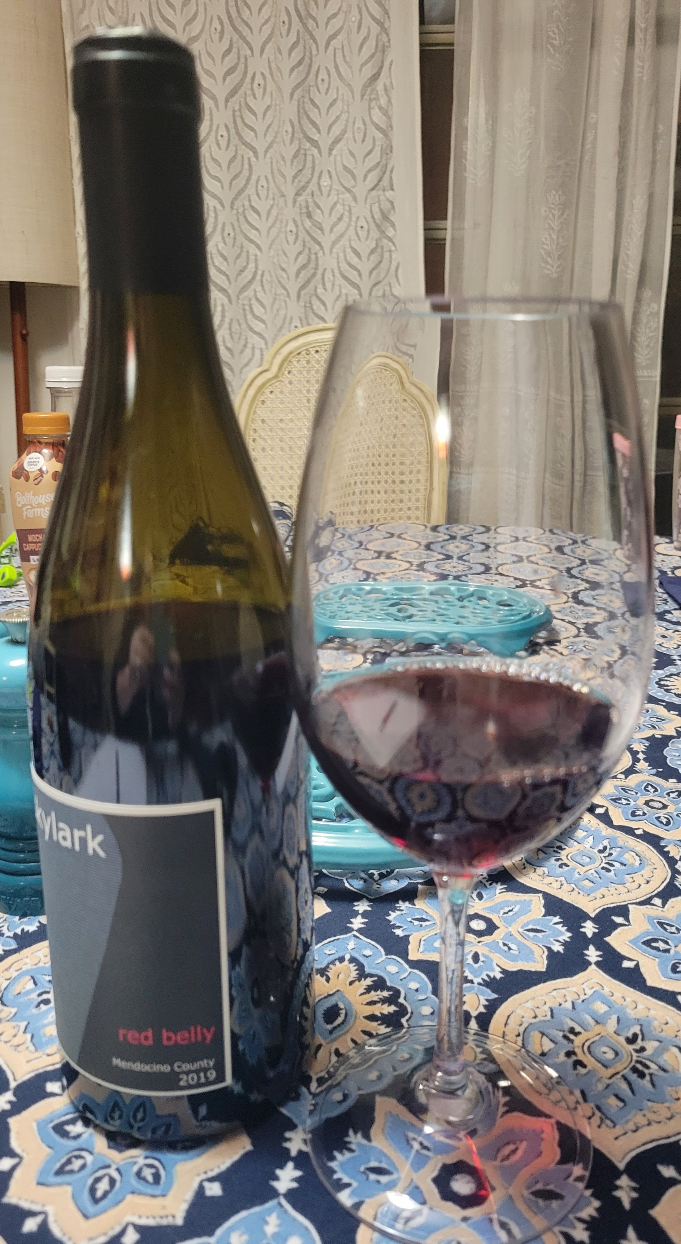 Skylark bottle and small amount of wine in a stemmed wine glass.