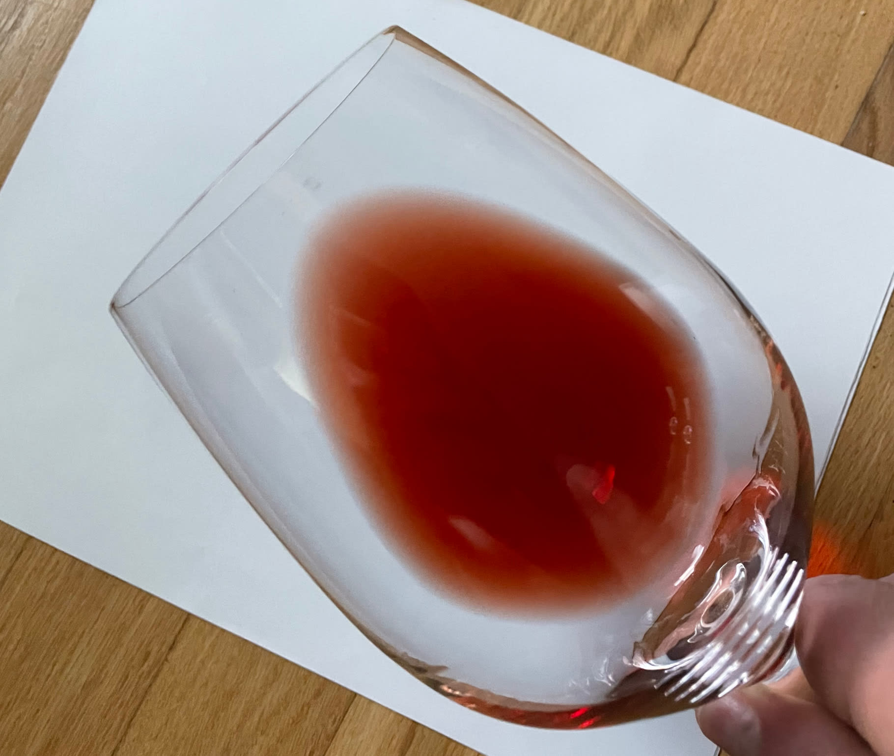 Wine in glass over white paper to show color