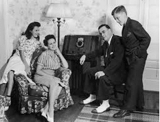 b&w photo gathered around radio console