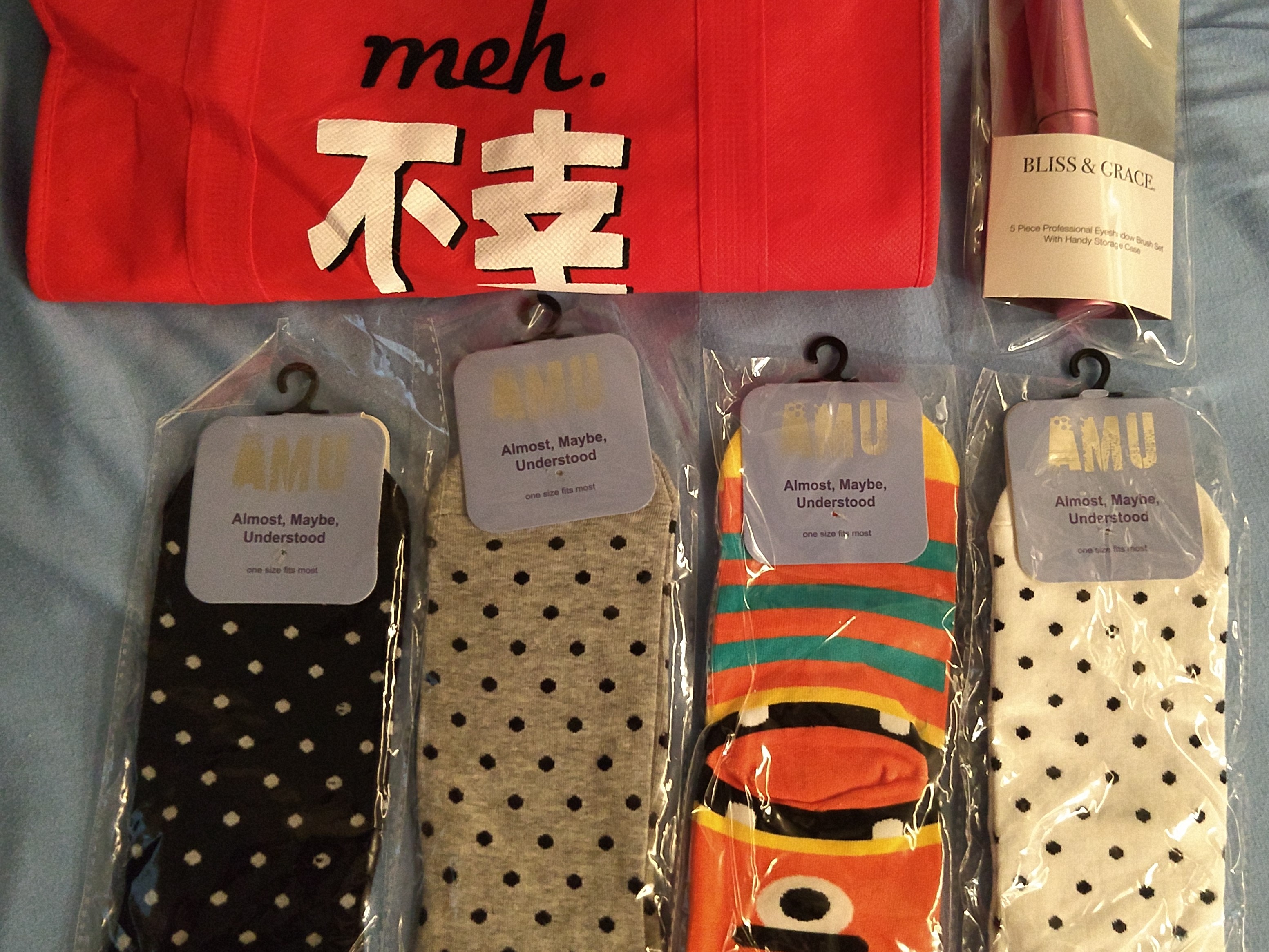 4 pairs of kids socks, a red fuku bag, and some brushes